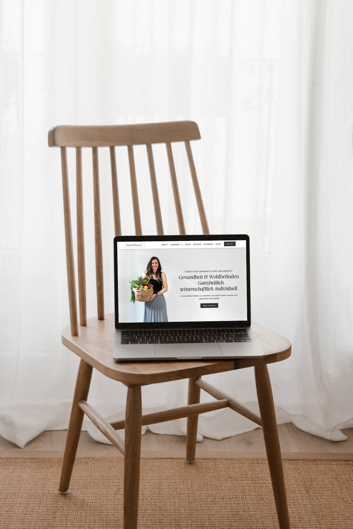 ein Laptop Mockup mit Screenshot der Website von Hannah Willemsen auf einem Holzstuhl