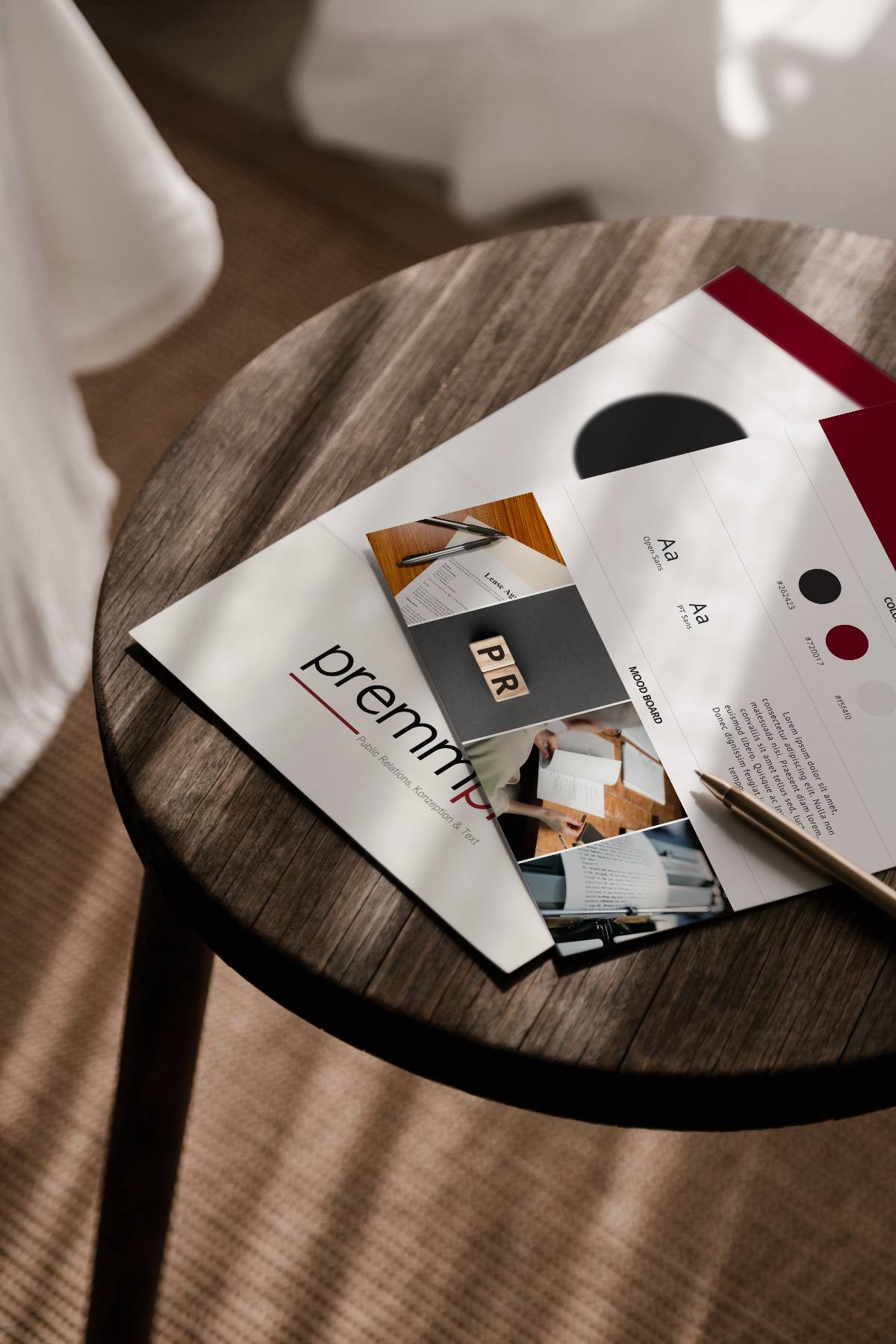 Mockup von 2 gedruckten Moodboard Seiten auf einem runden Holztisch