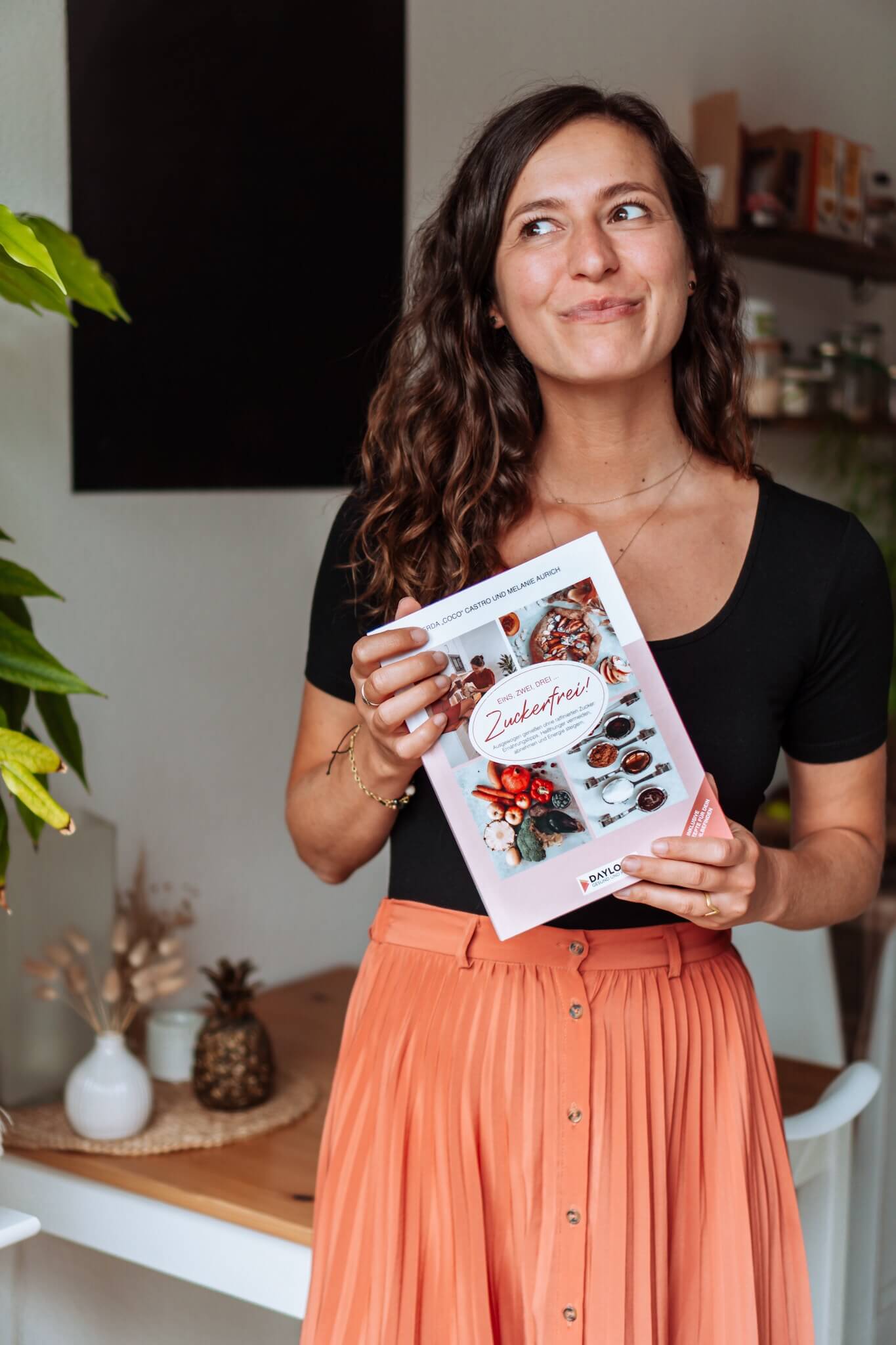 Frau hält ein Rezept-Buch in den Händen